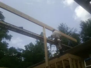 Carpenter setting a ridge beam over a new addition frame — Ice Dam Removal by Roofing Brothers in Fort Collins