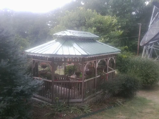 Green metal roof on a backyard gazebo surrounded by garden beds in Fort Collins